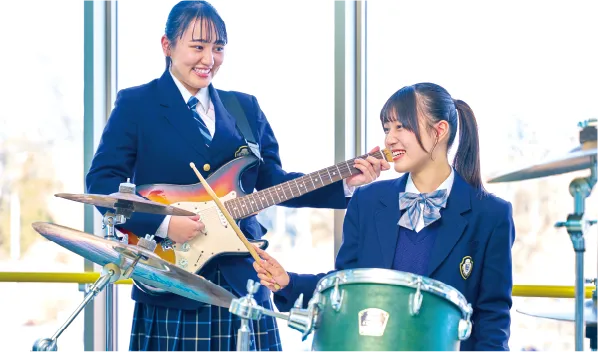 女子高校生がギターとドラムを演奏している写真